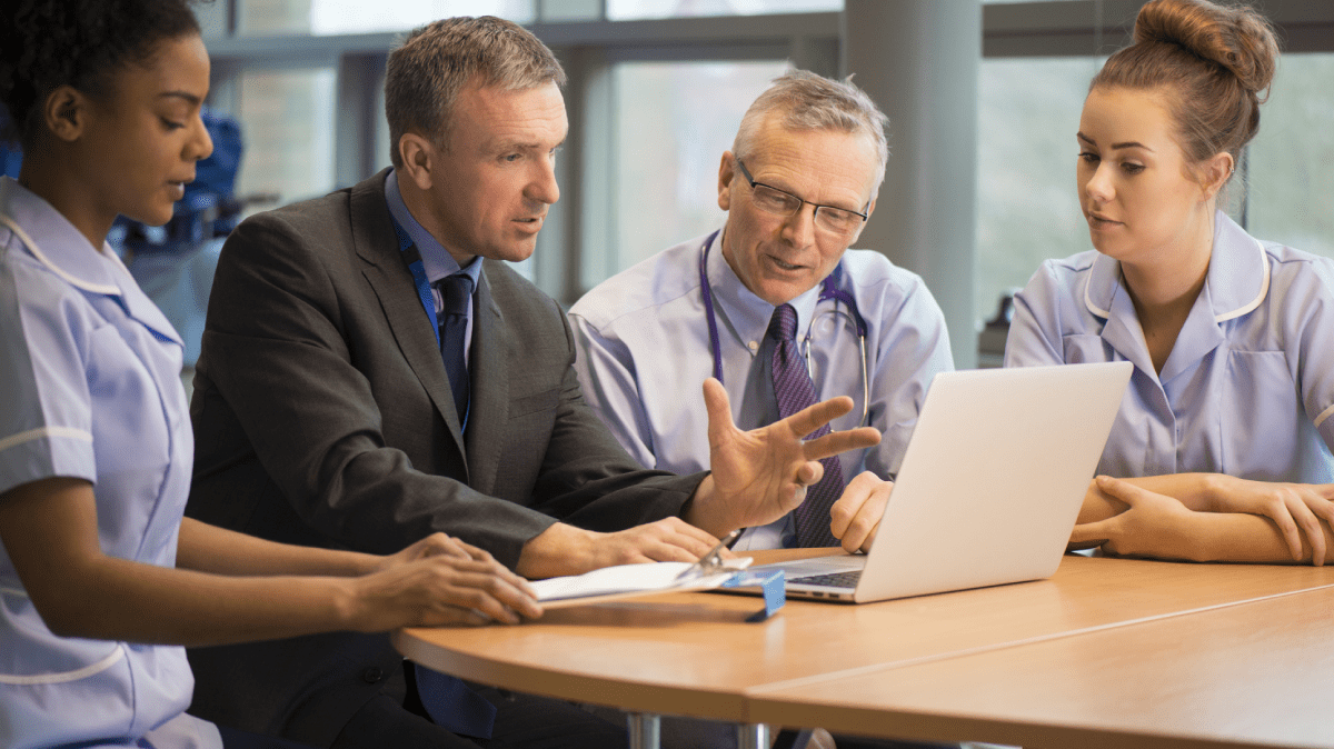 people around a laptop on a table